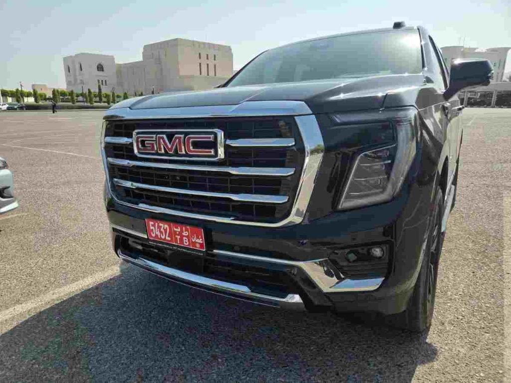 Чёрный внедорожник GMC спереди на открытой парковке