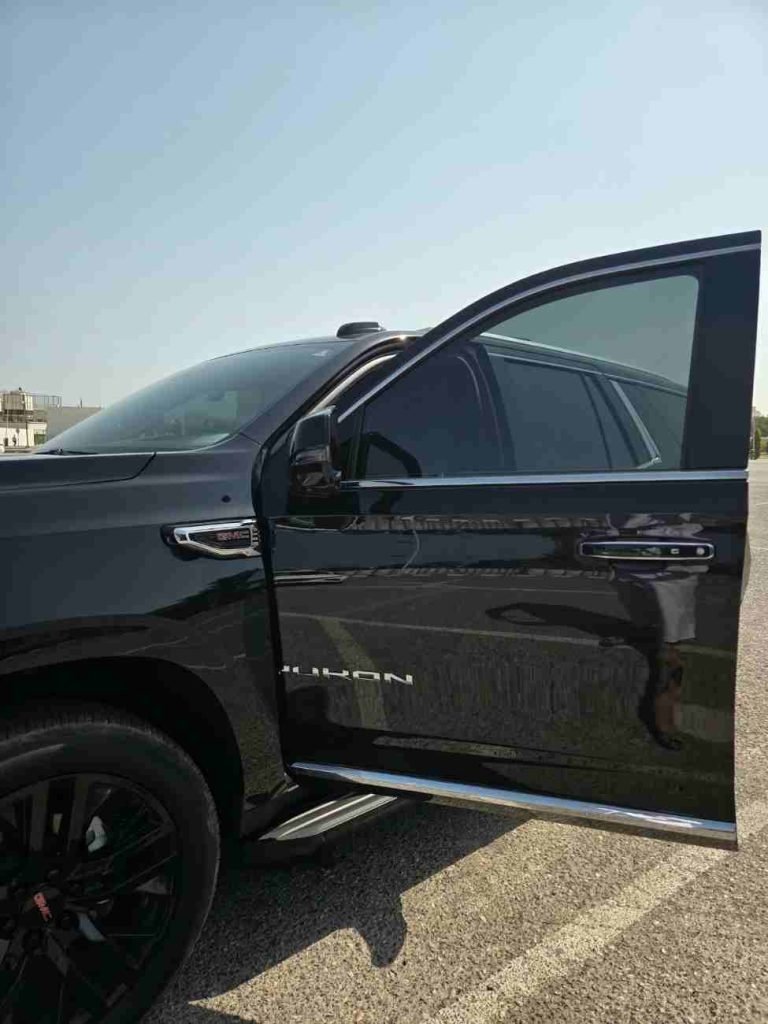 Чёрный внедорожник GMC Yukon с открытой передней дверью