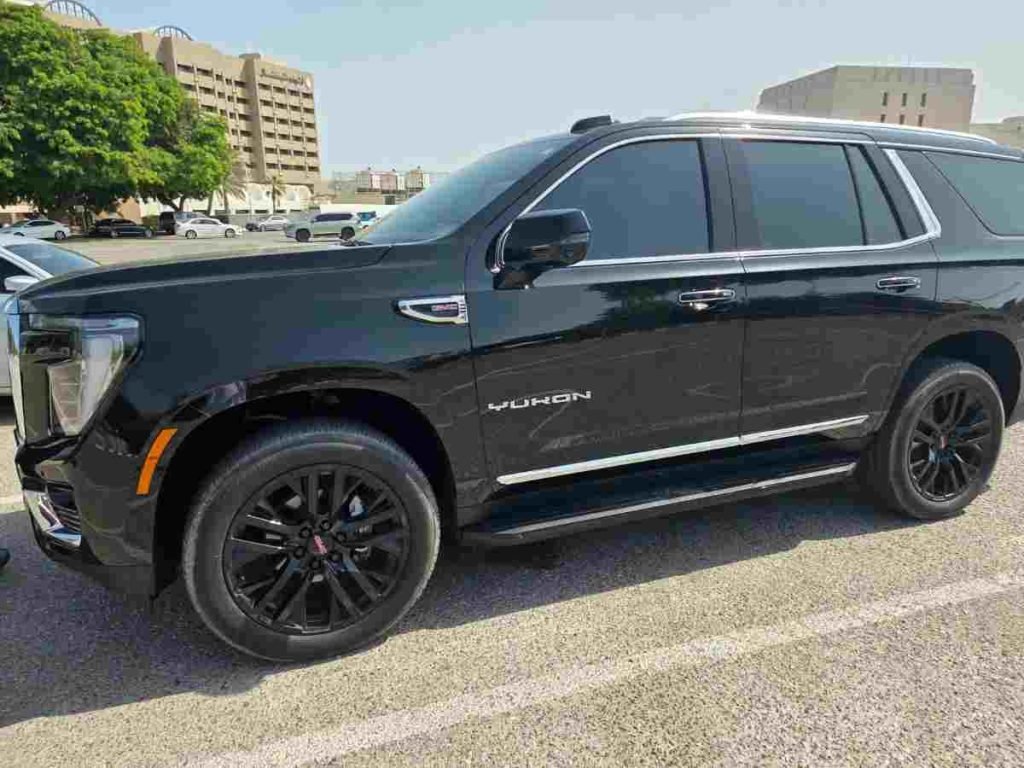 Чёрный внедорожник GMC Yukon сбоку на парковке